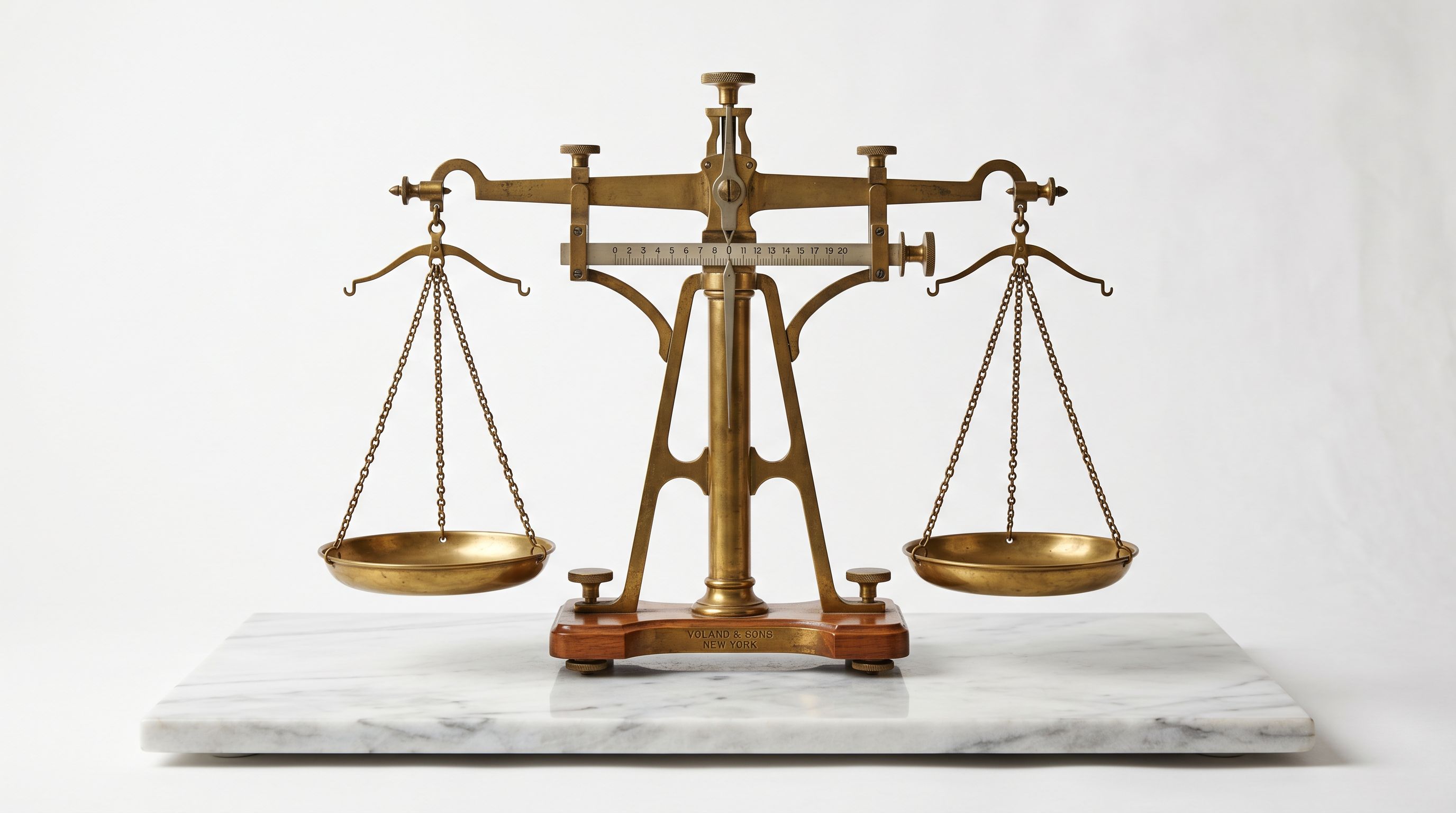 Vintage analytical balance scale with brass weighing pans in precise equilibrium on marble.