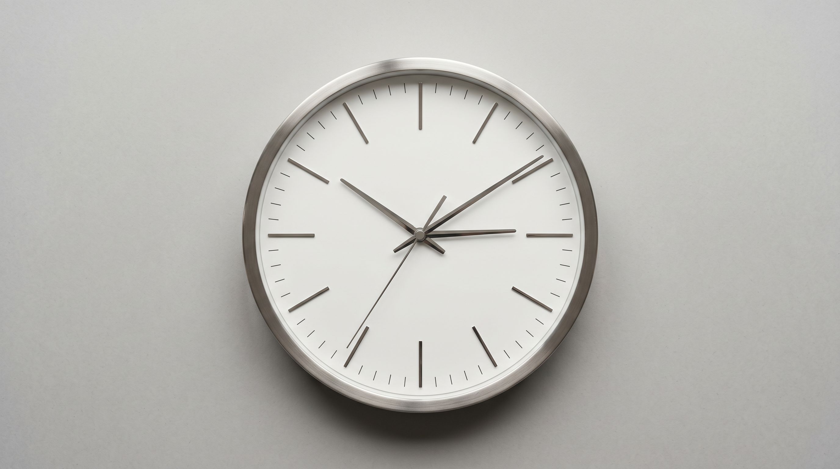 Minimalist analogue clock photographed from above representing the significant time cost of manual catalogue migration.