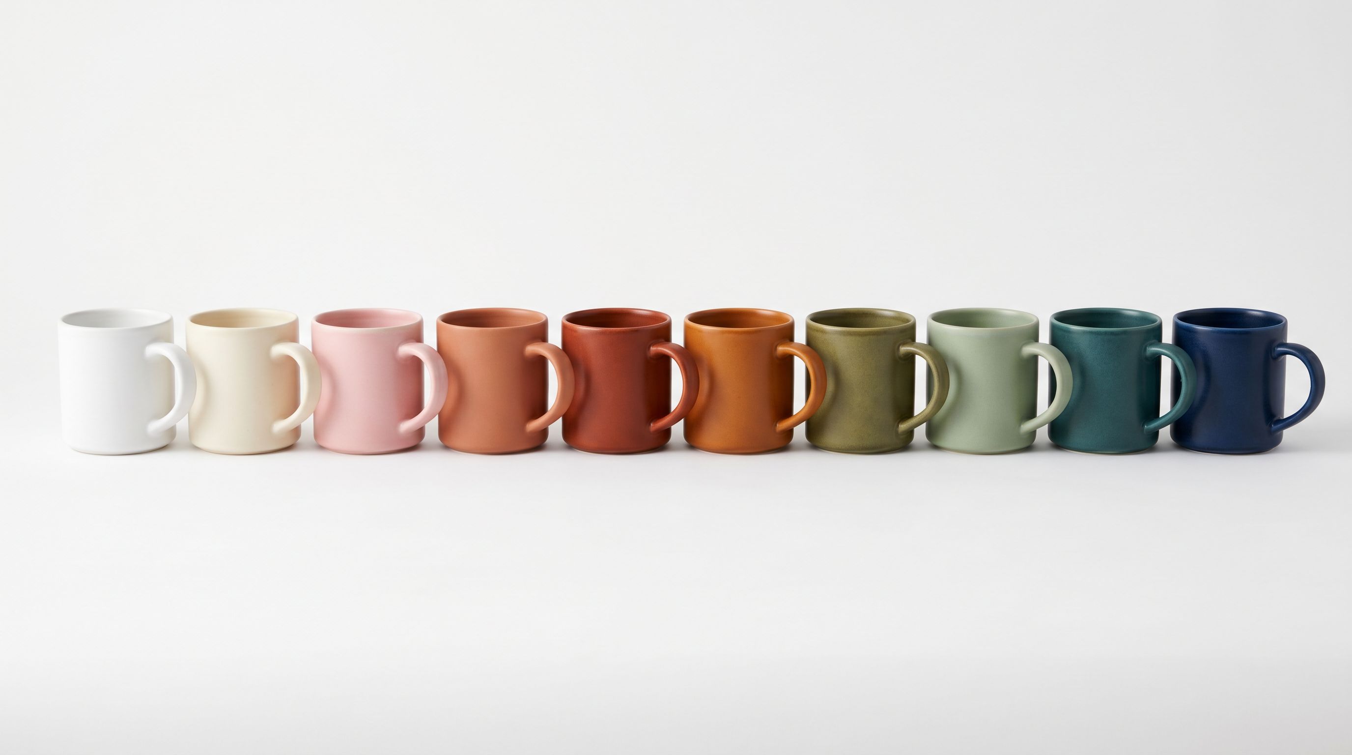 A row of ceramic mugs in a precise colour spectrum representing product variants grouped by colour.