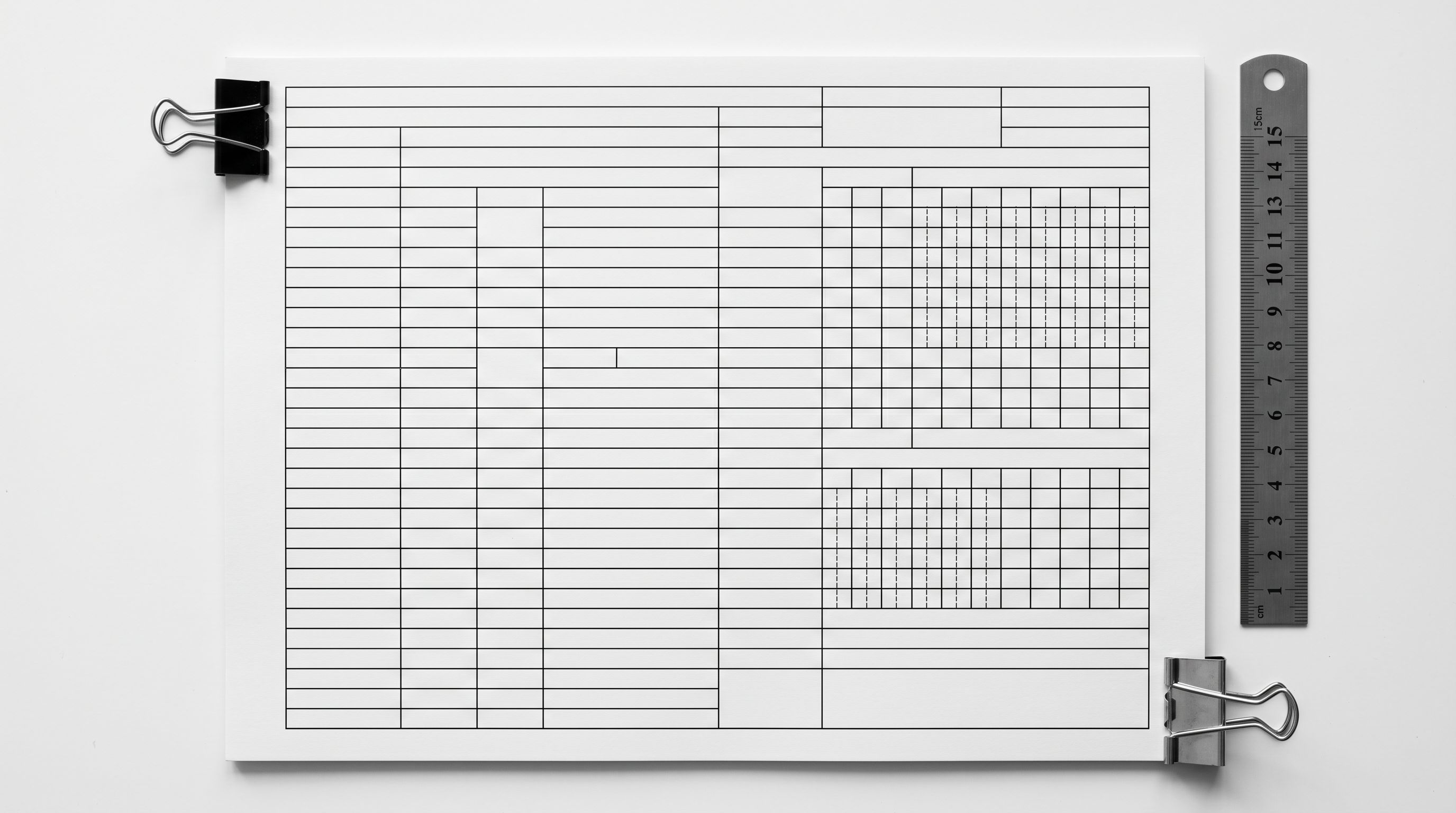Product data specification sheet with form lines and document clips on a surface.