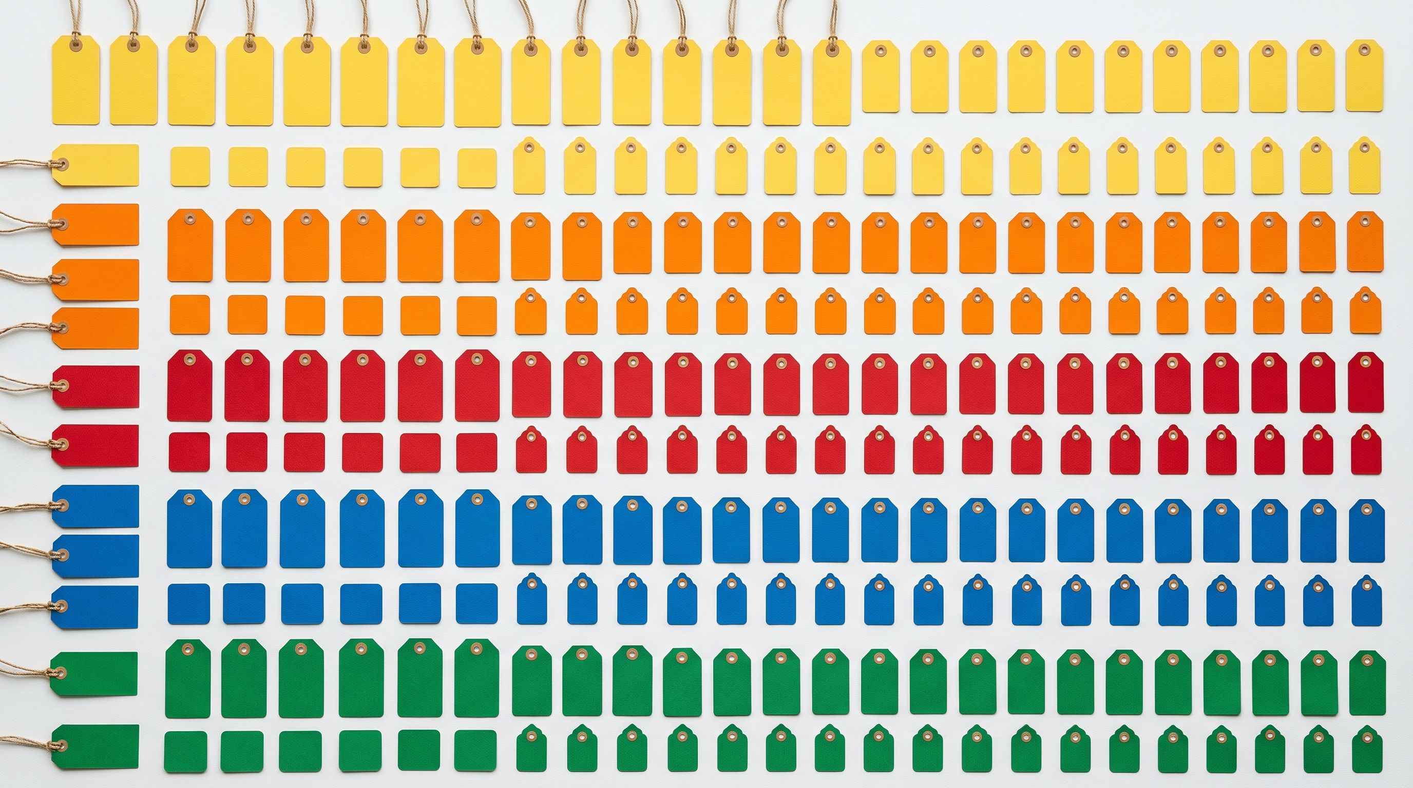 Colour-coded product price tags sorted in organised rows on a white surface.