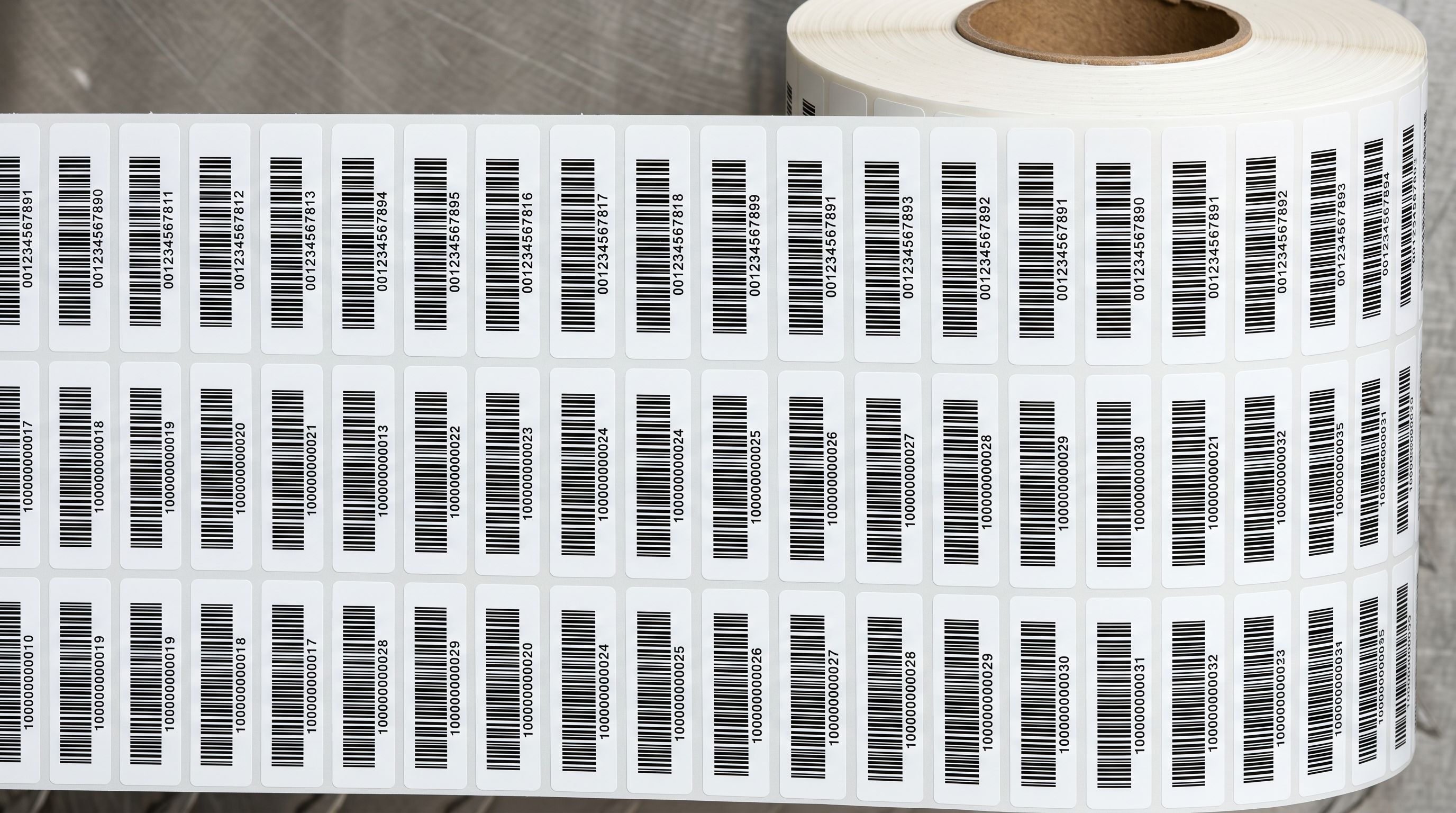 Close-up overhead view of freshly printed barcode labels on an adhesive label roll.