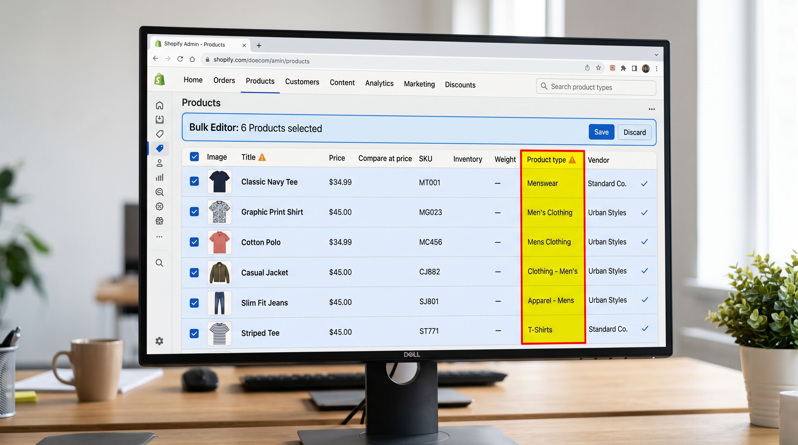 A Shopify admin interface on a monitor showing the Products section with the bulk editor open, several rows of products visible with the Product Type column highlighted showing mixed values: Mens Clothing, Men's Clothing, Menswear, and menswear all in the same column, demonstrating the catalogue drift that occurs when no product data standard exists, everything in sharp focus no blur no depth of field, colour photography.