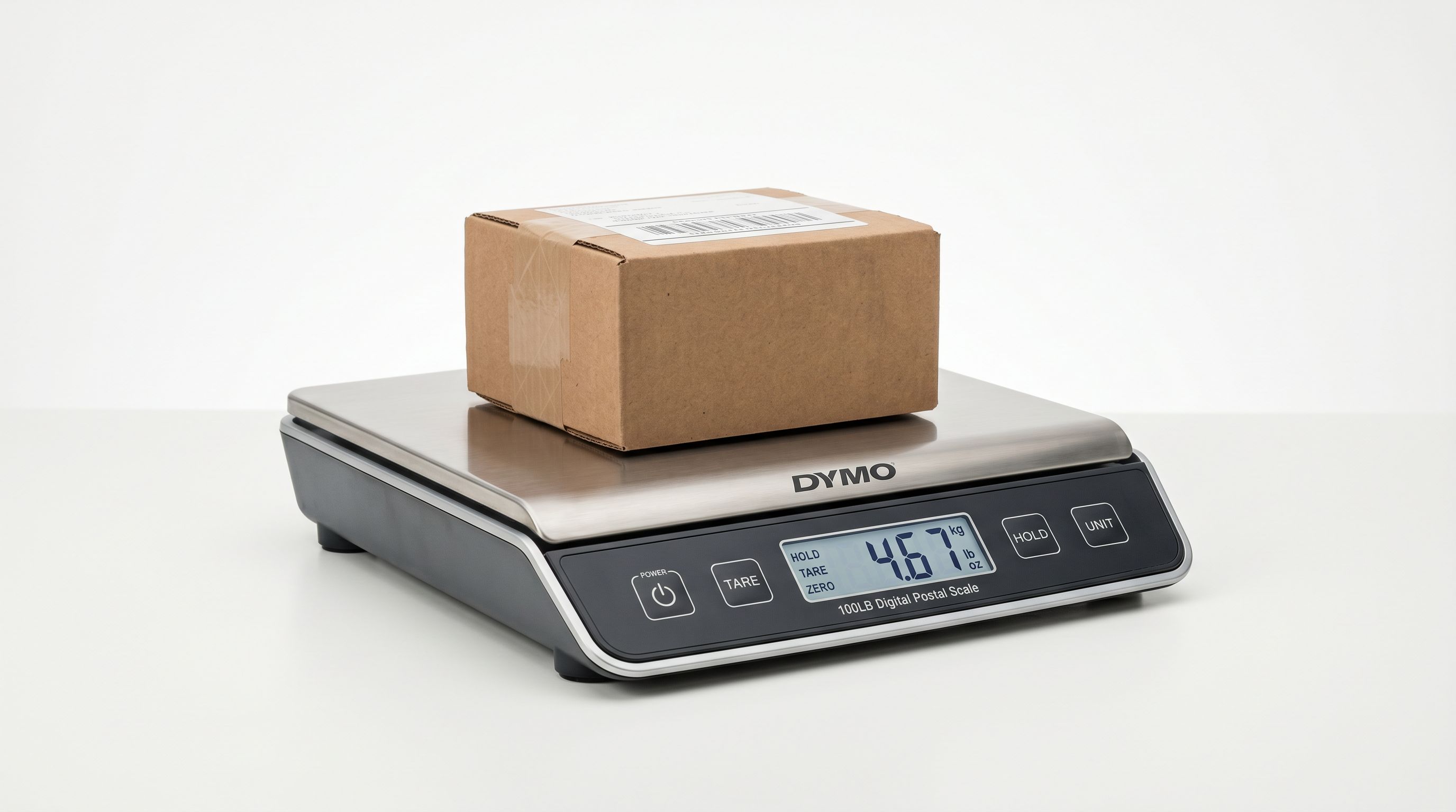A modern digital postal scale with a small cardboard parcel on the weighing platform against a clean white background.