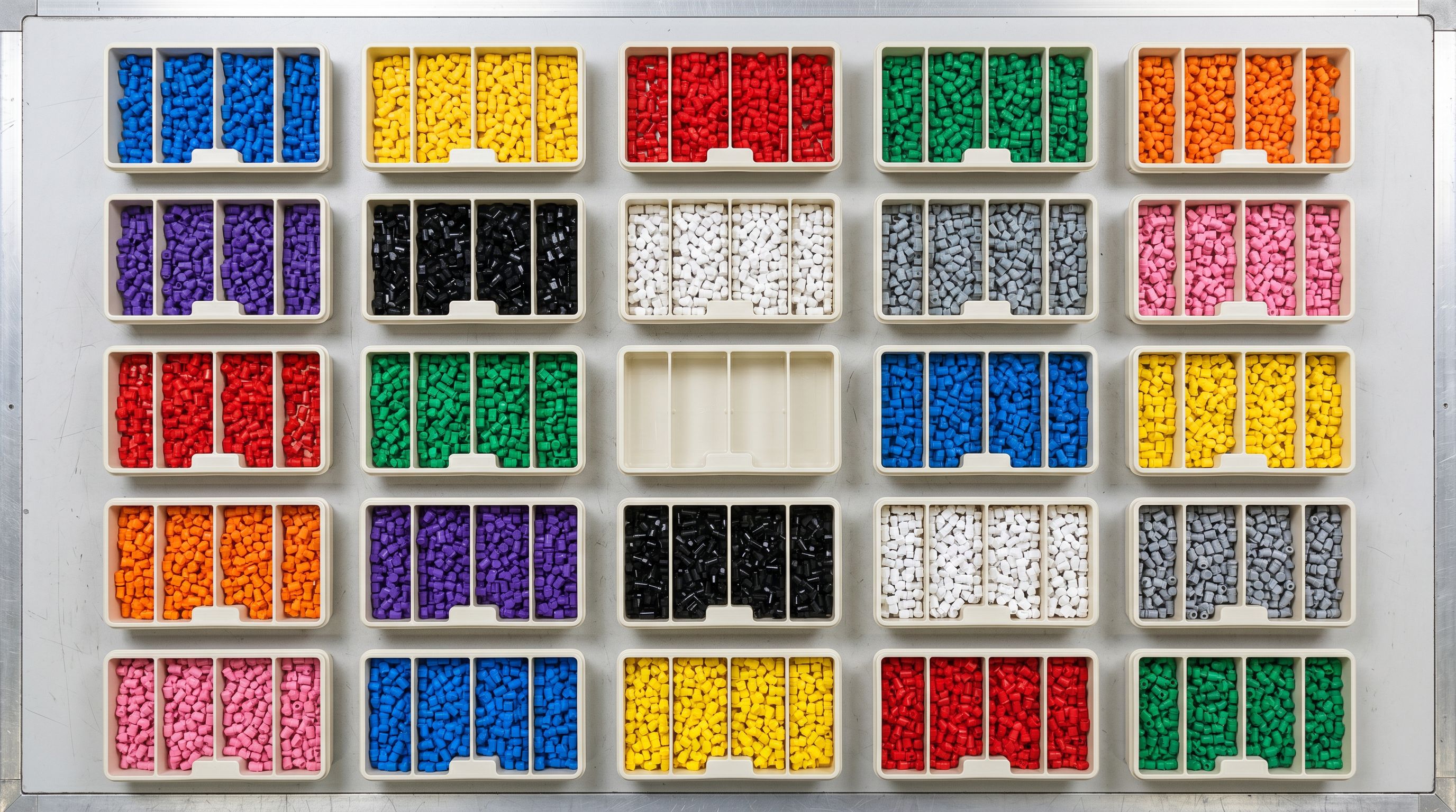 Overhead view of colour-coded sorting trays on a workbench, one tray conspicuously empty.