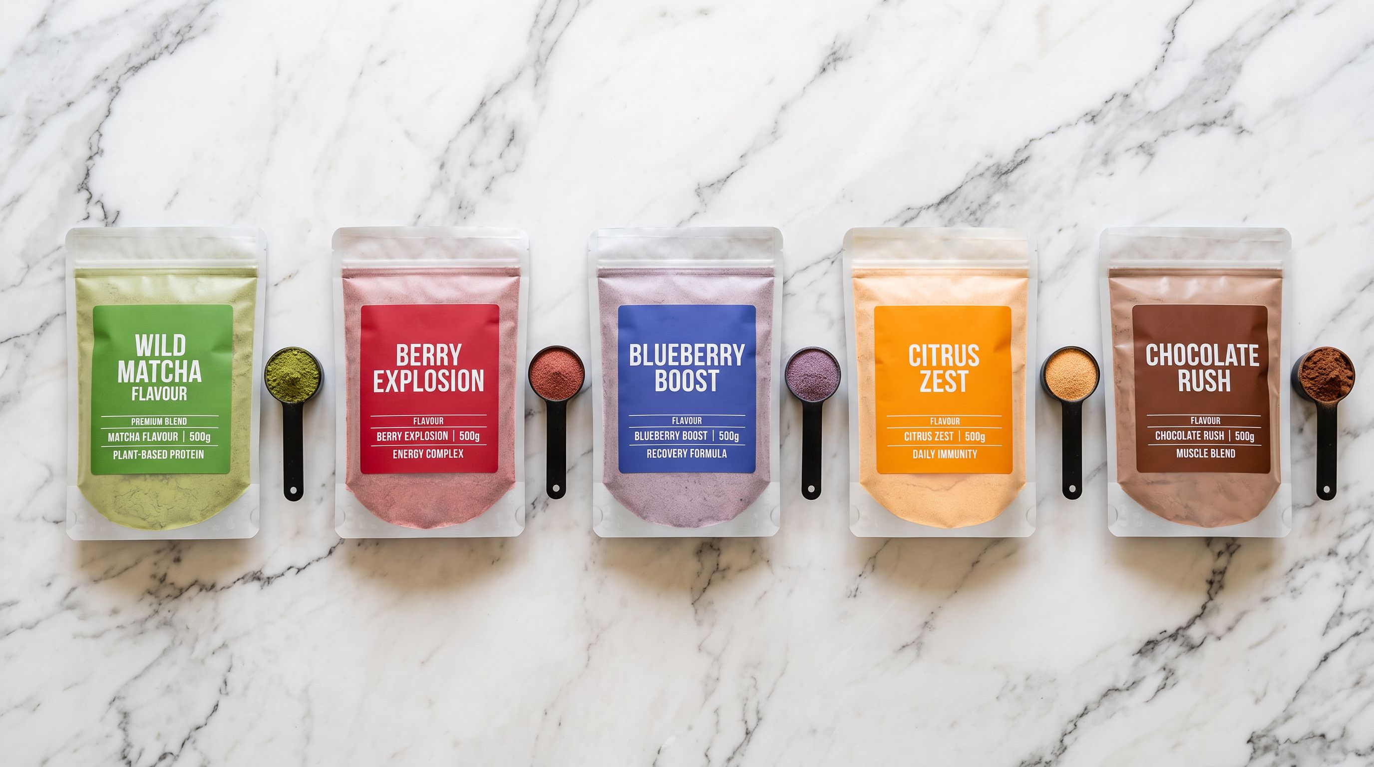 A flat lay of sealed supplement pouches in different flavours arranged on a clean marble surface with measuring scoops beside each pouch.